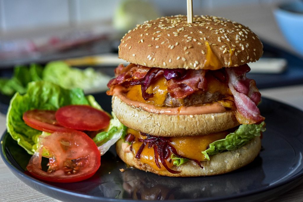 A zoomed in image of platter of hamburger and veggies on the side